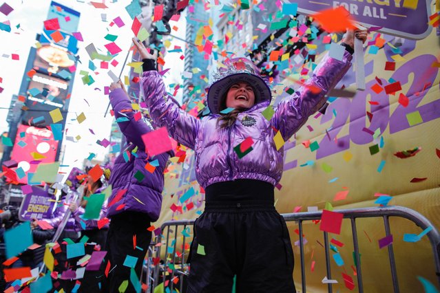 A woman reacts as confetti falls during a New Year's eve rehearsal in Times Square in New York on December 29, 2023. (Photo by AFP Photo/Stringer)