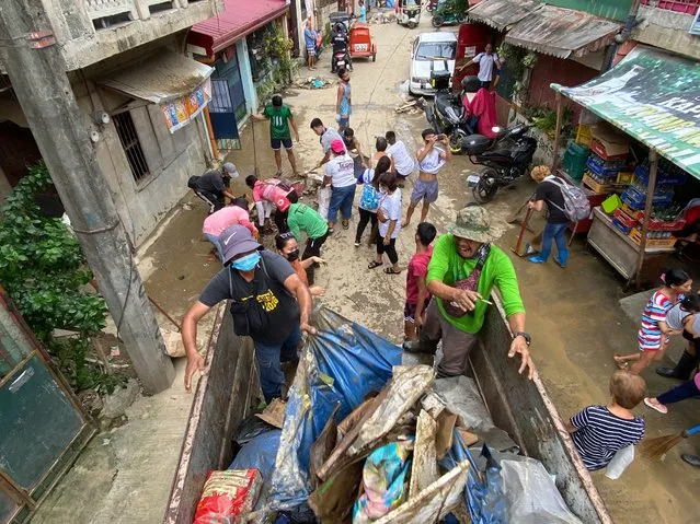 Residents and government laborers clear debris on a road in the aftermath of typhoon Noru in Marikina city, Metro Manila, P​hilippines 26 September 2022. (Photo by Francis R. Malasig/EPA/EFE)