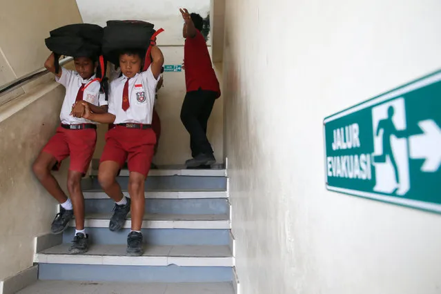 Indonesian students take part in an earthquake and tsunami evacuation drill in Nusadua, Bali, Indonesia, 15 August 2017. Hundreds of students and volunteers, including rescue teams, took part in a drill to prepare emergency response procedures for earthquakes and tsunamis. (Photo by Made Nagi/EPA)