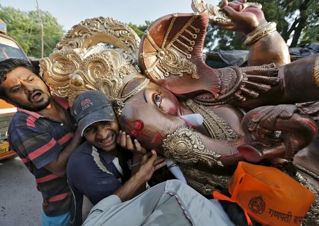 Devotees carry an idol of Hindu elephant god Ganesh, the deity of prosperity, while it is carried to a place of worship in Ahmedabad, India, September 16, 2015. Idols of Ganesh are made two to three months before Ganesh Chaturthi, a popular religious festival in India. (Photo by Amit Dave/Reuters)