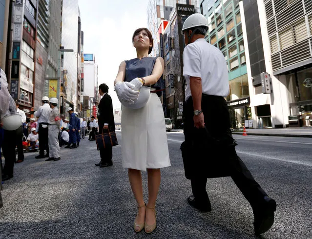 People wearing and holding helmets take part in a drill simulating a 7.2 magnitude earthquake in Tokyo, Japan, August 26, 2016. (Photo by Kim Kyung-Hoon/Reuters)