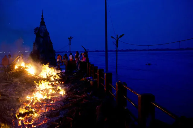 In this Thursday, August 25, 2016 photo, Hindu funerals are performed atop of a Hindu temple at the flooded Manikarnika Ghat in Varanasi, India. (Photo by Tsering Topgyal/AP Photo)