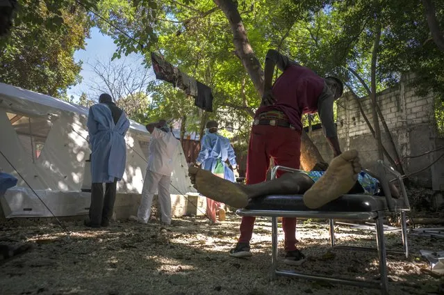 The body of Stanley Joliva who died of cholera symptoms lies on a stretcher while a relative touches him, at a clinic run by Doctors Without Borders in Port-au-Prince, Haiti, Thursday, October 27, 2022. (Photo by Ramon Espinosa/AP Photo)