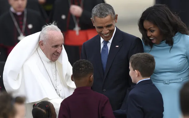 Pope Francis, left, greets children as he is escorted by President Barack Obama, center, and first lady Michelle Obama, right, after arriving at Andrews Air Force Base, Md., Tuesday, September 22, 2015. The Pope is spending three days in Washington before heading to New York and Philadelphia. This is the Pope's first visit to the United States. (Photo by Susan Walsh/AP Photo)