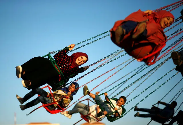 Palestinians enjoy a ride in an amusement park on the last day of Eid al-Fitr celebrations, in Gaza City July 8, 2016. (Photo by Mohammed Salem/Reuters)