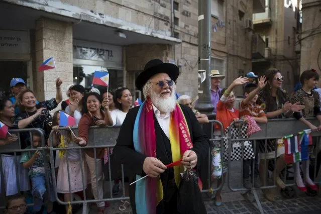 An ultra-Orthodox Jewish man looks at participants during an annual parade on the Jewish holiday of Sukkot in Jerusalem October 1, 2015. Thousands of foreigners who support Israel took part on Thursday in the parade along with groups of Israelis. (Photo by Ronen Zvulun/Reuters)