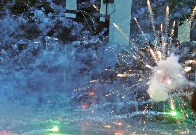 Firecrackers thrown by protesters explode in front of riot police amid clashes in the vicinity of the parliament in central Beirut on August 10, 2020 following a huge chemical explosion that devastated large parts of the Lebanese capital. (Photo by AFP Photo/Stringer)