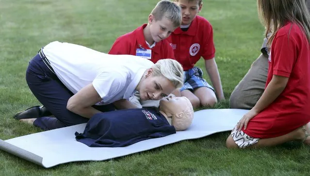 Monaco's Princess Charlene, goodwill ambassador for the International Federation of Red Crosses and Red Crescents Societies (IFRC) for first aid, demonstrates on a dummy how to practice first aid to chidren during the launch of World First Aid Day 2016 at the United Nations in Geneva, Switzerland September 9, 2016. (Photo by Denis Balibouse/Reuters)
