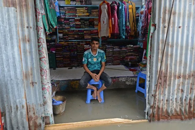 A shopkeeper waits for customers inside his flooded store in Sreenagar on July 20, 2020. The death toll from heavy monsoon rains across South Asia has climbed to nearly 200, officials said on July 19, as Bangladesh and Nepal warned that rising waters would bring further flooding. (Photo by Munir Uz Zaman/AFP Photo)