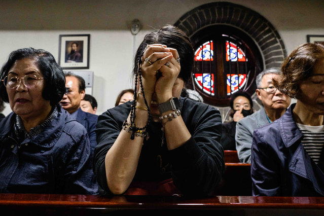 People pray as they pay their respects near a portrait of Pope Francis displayed inside Myeongdong Cathedral on April 22, 2025 in Seoul, South Korea. Pope Francis, the first Latin American and Jesuit pope, died on Easter Monday at the age of 88 at the Vatican's Casa Santa Marta after battling pneumonia and other health issues. His death marks the end of a 12-year papacy characterized by efforts to reform the Church, advocate for the marginalized, and promote inclusivity, and it initiates the traditional process of selecting a new pope. (Photo by Anthony Wallace – Pool/Getty Images)