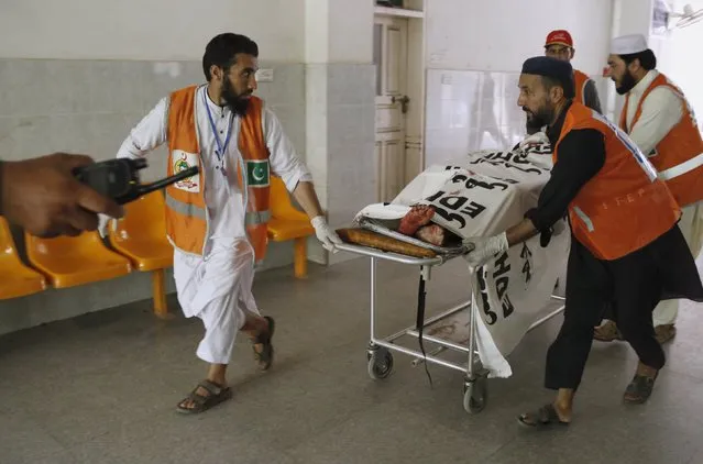 Emergency workers wheel an injured man to a hospital after an attack on an air force base in Peshawar, Pakistan, September 18, 2015. Taliban gunmen stormed a Pakistani Air Force base early on Friday, killing at least 17 people, a military spokesman said, the deadliest attack on a military installation this year. (Photo by Khuram Parvez/Reuters)