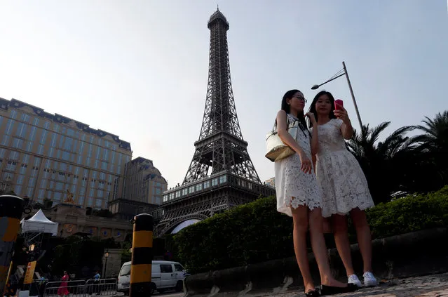 Visitors take a selfie in front of a replica of Eiffel Tower at Parisian Macao as part of Las Vegas Sands development in Macau, China September 13, 20166. (Photo by Bobby Yip/Reuters)