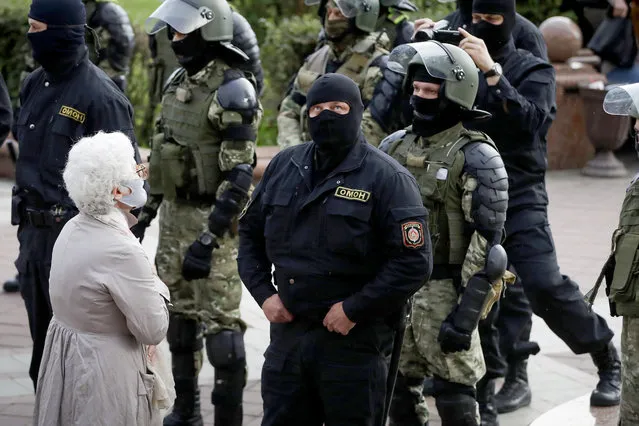 A woman reacts in front of a riot police blockade during a protest at the Independence Square in Minsk, Belarus, Thursday, August 27, 2020. Police in Belarus have dispersed protesters who gathered on the capital's central square, detaining dozens. (Photo by Sergei Grits/AP Photo)