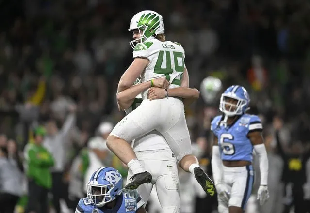 Oregon place-kicker Camden Lewis (49) is lifted by Adam Barry (93) after Lewis kicked an extra point against North Carolina during the second half of the Holiday Bowl NCAA college football game Wednesday, December 28, 2022, in San Diego. (Photo by Denis Poroy/AP Photo)