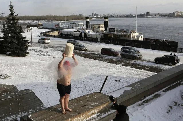 Yevgeny Panteleikin, a local blogger, dumps a bucket of cold liquid nitrogen on himself during a flash mob on the embankment of the Yenisei River in Krasnoyarsk, Siberia, November 20, 2014. (Photo by Ilya Naymushin/Reuters)