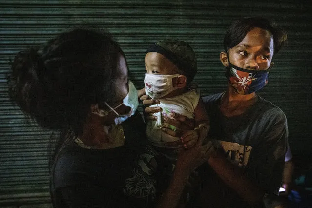 A homeless teenage couple carry their months-old infant as they queue to receive free meals from volunteers on August 7, 2020 in Caloocan, Metro Manila, Philippines. The Philippine economy suffered its worst slump on record in the second quarter, falling into recession for the first time in 29 years as economic activity reels from months of strict coronavirus restrictions which has left millions of Filipinos jobless and hungry. Analysts expect the economic hit to worsen with President Rodrigo Duterte reimposing a strict lockdown in capital Manila and surrounding provinces amid resurging coronavirus infections which has breached 100,000 cases. Duterte's move came after nearly 100 medical organizations representing 80,000 doctors and a million nurses called for tighter controls and warned that the country's health systems are being overwhelmed by the surge of cases and are close to collapsing as health workers fall ill or resign out of fear and exhaustion. (Photo by Ezra Acayan/Getty Images)
