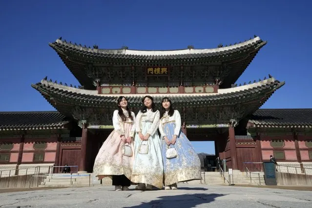 Hong Kong travelers wearing South Korean traditional “Hanbok” costume pose to take photos at the Gyeongbok Palace, the main royal palace during the Joseon Dynasty, and one of South Korea's well known landmarks in Seoul, South Korea on January 16, 2023. (Photo by Ahn Young-joon/AP Photo)