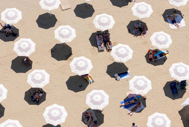This aerial photograph shows people sunbathing on a beach in Vlora, some 160 km South West of Tirana, Albania, on June 24, 2025. (Photo by Adnan Beci/AFP Photo)