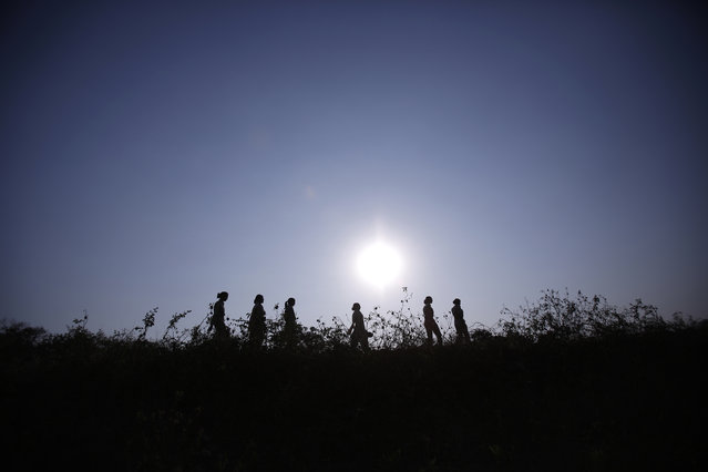 Forest guards are silhouetted as they patrol at Gir National Park and Wildlife Sanctuary in Sasan, Gujarat December 1, 2014. (Photo by Anindito Mukherjee/Reuters)