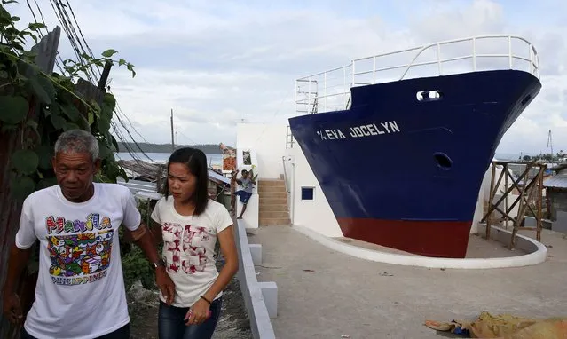 Residents walk past a cargo ship that was swept during the onslaught of Typhoon Haiyan in Tacloban city in central Philippines November 2, 2015, ahead of the second anniversary of a devastating typhoon that killed more than 6000 people in central Philippines. (Photo by Erik De Castro/Reuters)