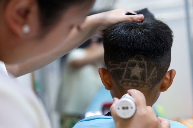 Hair salon owner Wang Xueru gives a child a haircut in a design of a tank to commemorate the 80th anniversary of the end of World War Two, at her store in Beijing, China on August 28, 2025. (Photo by Tingshu Wang/Reuters)