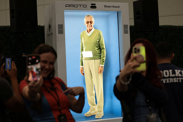 Attendees take selfies in front of an AI hologram of comic book writer Stan Lee projected into a Proto Epic device during L.A. Comic Con in Los Angeles, California, U.S., September 26, 2025. (Photo by Mario Anzuoni/Reuters)
