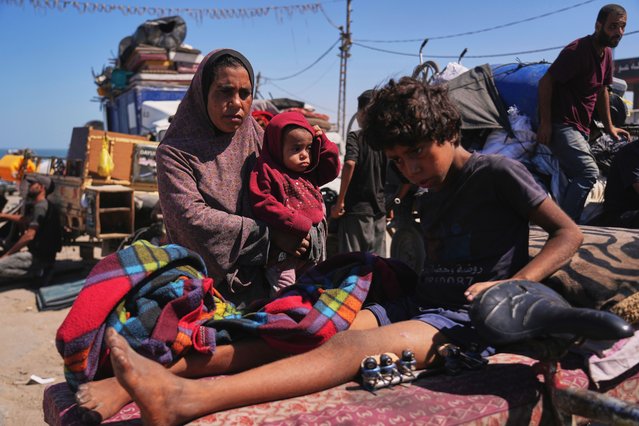 Amal Al-Qishawi, follows her injured son, Yasser, 11, carried on a bicycle by his father Rafiq Al-Qishawi, as they flee northern Gaza Strip walking along the coastal road, near Wadi Gaza, Saturday, September 20, 2025. (Photo by Abdel Kareem Hana/AP Photo)