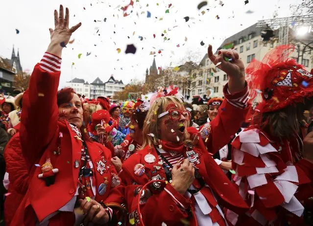 Carnival revellers throw confetti as they celebrate the start of the carnival season in Cologne November 11, 2015. (Photo by Wolfgang Rattay/Reuters)