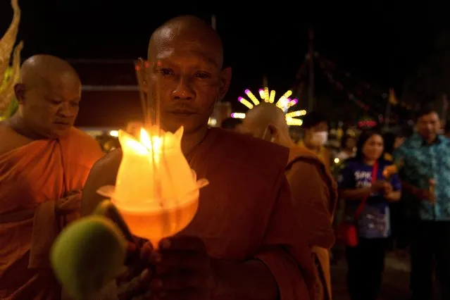 Budhist monks carry candles and flowers as they walks around Wat Cherngtalay temple during the commemoration of Makha Bucha Day in Phuket, Thailand on March 6, 2023. (Photo by Jorge Silva/Reuters)