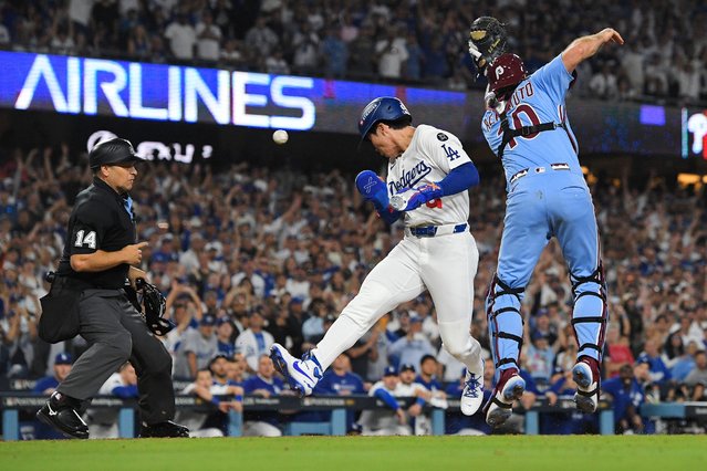 Los Angeles Dodgers' Hyeseong Kim, center, scores the game-winning run past Philadelphia Phillies catcher J.T. Realmuto (10) on a ground ball by Andy Pages and a throwing error by Phillies pitcher Orion Kerkering during the eleventh inning in Game 4 of baseball's National League Division Series Thursday, October 9, 2025, in Los Angeles. (Photo by Mark J. Terrill/AP Photo)