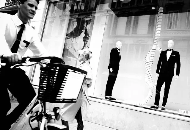 A man ries past a shop window on a street in Cannes. (Photo by Gareth Cattermole/Getty Images)