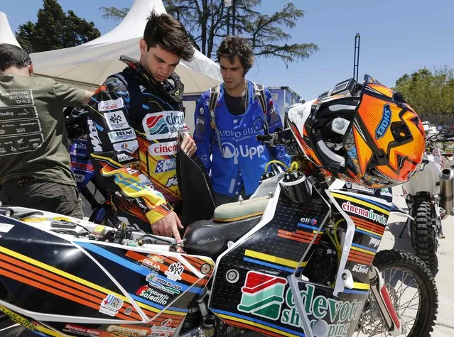 Husqsvarna rider Enrique Guzman (R) of Chile talks with KTM rider Jorge Lacunza of Argentina as they await technical verification ahead of the Dakar Rally 2015 in Buenos Aires January 2, 2015. (Photo by Enrique Marcarian/Reuters)