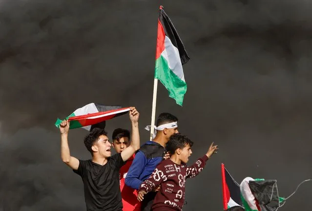 Palestinians take part in a protest against the holding of the annual flag march in Jerusalem which marks Jerusalem Day, at the Israel-Gaza border fence east of Gaza City on May 18, 2023. (Photo by Mohammed Salem/Reuters)