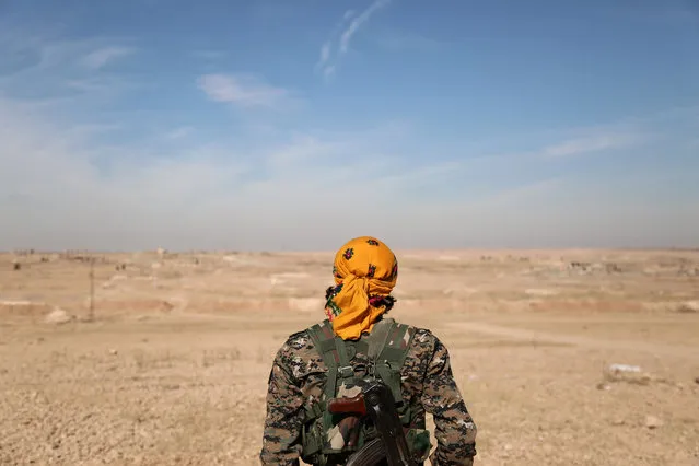 An Syrian Democratic Forces (SDF) fighter stands with his weapon, north of Raqqa city, Syria November 7, 2016. (Photo by Rodi Said/Reuters)