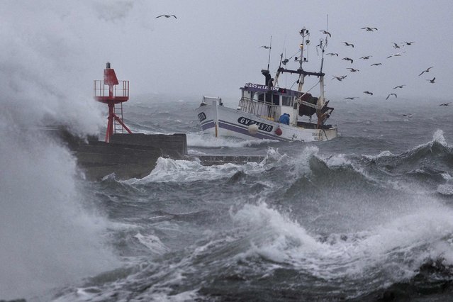 A fishing boat arrives at the port in Plobannalec-Lesconil, western France, October 22, 2025, as huge waves and strong winds hit the coast at the passage of the storm Benjamin. (Photo by Fred Tanneau/AFP Photo)