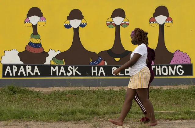 A woman walks past a coronavirus-themed mural promoting the use of face mask in public place, in Sebokeng, Vereeniging, South Africa, Thursday, January 28, 2021. (Photo by Themba Hadebe/AP Photo)