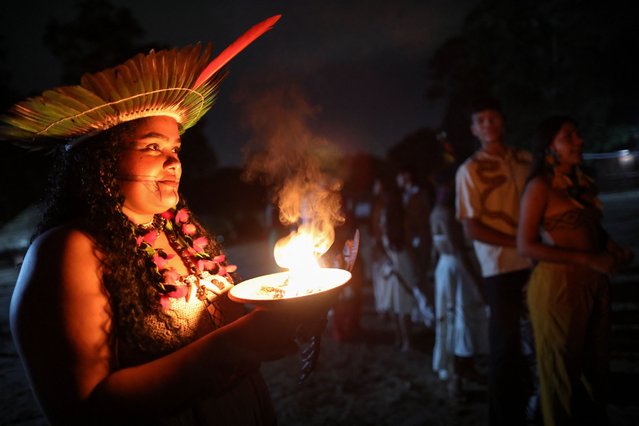 An indigenous woman looks on as she holds a smoking pot during the inauguration of “Cine Aldeia”, the first cinema in an indigenous territory in Amazonas state, in Manaus, Brazil, on February 1, 2025. (Photo by Michael Dantas/AFP Photo)