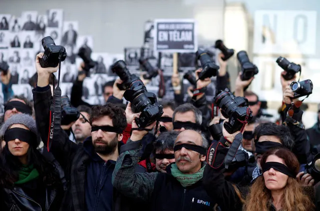 Photojournalists from Argentina' s national press photographers association ARGRA hold up their cameras and shout slogans outside Telam, a national news agency, to protest the layoffs of some 350 Telam journalists who are now occupying the agency' s headquarters, in Buenos Aires, Argentina, Wednesday, July 11, 2018. About 40 percent of the agency' s employees were let go in June. (Photo by Martin Acosta/Reuters)