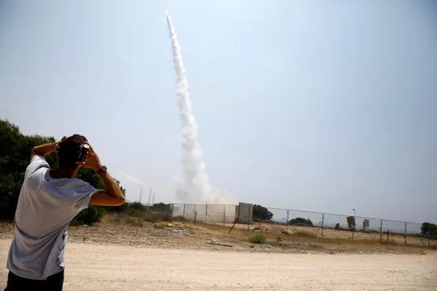 An Israeli man looks on as an Iron Dome launcher fires an interceptor rocket in the southern Israeli city of Ashkelon July 14, 2018. (Photo by Amir Cohen/Reuters)