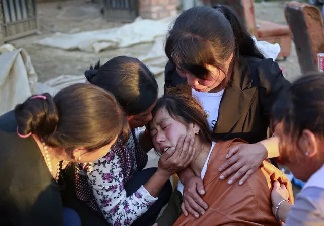 Family members console a woman who lost her daughter in a 6.6 magnitude earthquake in Minxian county, Dingxi, Gansu province July 22, 2013. The earthquake in China's western Gansu province killed at least 89 people with hundreds injured as many homes in affected areas collapsed, state media said on Monday. (Photo by Reuters/China Daily)