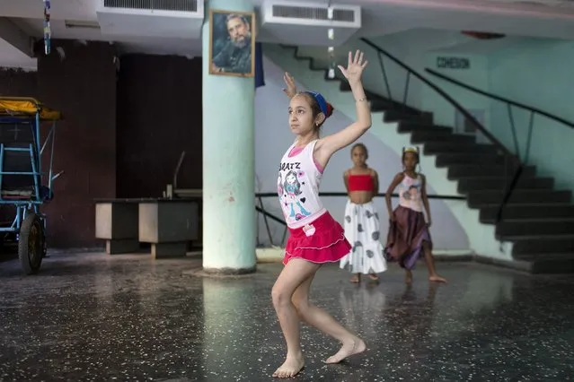 A girl takes part in a rehearsal of a contemporary Haitian dance under a picture of Cuban former president Fidel Castro in a communal center in downtown Havana, January 30, 2015. (Photo by Alexandre Meneghini/Reuters)