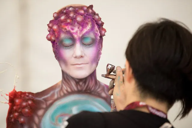 An artist paints a model during the annual “World Bodypainting Festival” in Klagenfurt, Austria, 14 July 2018. The world's biggest bodypainting event takes place from 12 to 14 July in Klagenfurt and celebrates its 20th anniversary this year. (Photo by Florian Wieser/EPA/EFE)