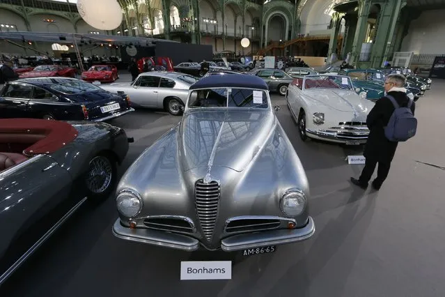 A visitor looks at vintage and classic cars displayed ahead of the Bonhams' Les Grandes Marques du Monde vintage motor cars and motorcycles auction at the Grand Palais exhibition hall as part of the Retromobile vintage car show in Paris February 4, 2015. (Photo by Gonzalo Fuentes/Reuters)