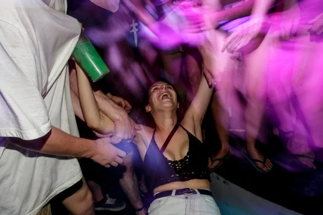 A girl dances at a party in a night club during Australian “schoolies” celebrations on November 26, 2014 in Kuta, Bali, Indonesia. This year around 6,000 students will travel to Bali to celebrate “Schoolies Week”, which marks the end of the school year. Destinations such as Kuta in Bali are popular among students in search of cheap alcohol and all night parties. (Photo by Agung Parameswara/Getty Images)