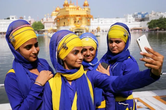 Baptised Sikh girls take a photo at the Golden Temple, the holiest of Sikh shrines during the 414th first installation anniversary of Sri Guru Granth Sahib, the holy book of Sikhs in Amritsar, India, 10 September 2018. Guru Arjan Dev, the fifth Sikh Guru, installed Guru Granth Sahib for the first time at the Golden Temple in the year 1604. (Photo by Raminder Pal Singh/EPA/EFE)