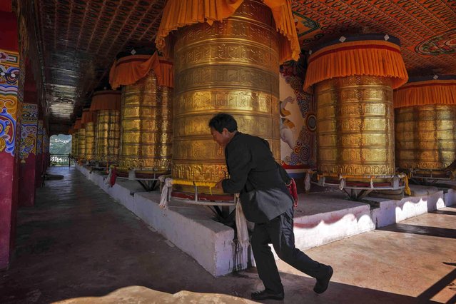 A Tibetan worshipper turns the prayer wheels at the Sangpiling Monastery in Xiangcheng county, Ganzi Tibetan Autonomous Prefecture of southwestern China's Sichuan province, Thursday, September 7, 2023. (Photo by Andy Wong/AP Photo)
