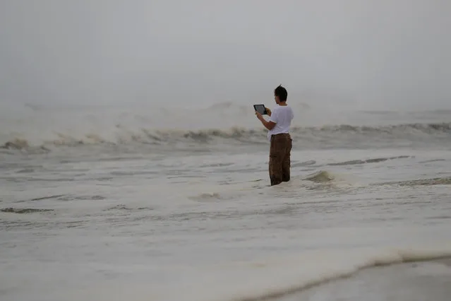 Peter Malave records the surf from encroaching Hurricane Michael, which is expected to make landfall today, in Panama City Beach, Fla., Wednesday, October 10, 2018. The hurricane center says Michael will be the first Category 4 hurricane to make landfall on the Florida Panhandle. (Photo by Gerald Herbert/AP Photo)