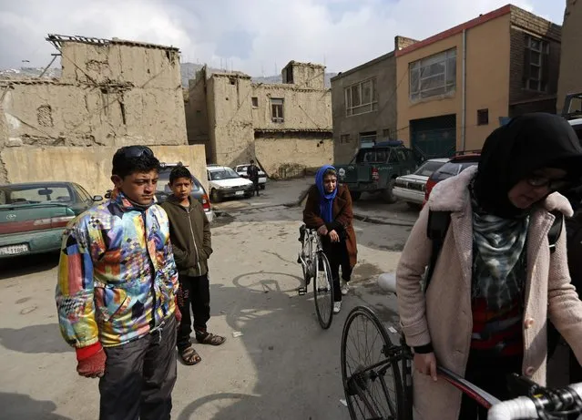 Zahra Alizada (R) and Frozan Rasooli (2nd R), members of Afghanistan's Women's National Cycling Team prepare themselves before training in Kabul February 20, 2015. (Photo by Mohammad Ismail/Reuters)