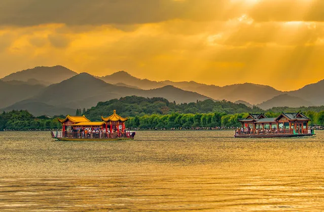 Visitors enjoy the sunset scenery of the West Lake in Hangzhou, East China's Zhejiang province on October 5, 2023. (Photo by Costfoto/NurPhoto/Rex Features/Shutterstock)