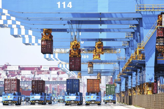 In this June 4, 2021, file photo, gantry cranes move containers onto transporters at a port in Qingdao in eastern China's Shandong province. China’s exports surged in June while import growth slowed to a still-robust level as its economic rebound from the coronavirus leveled off. (Photo by Chinatopix via AP Photo, File)